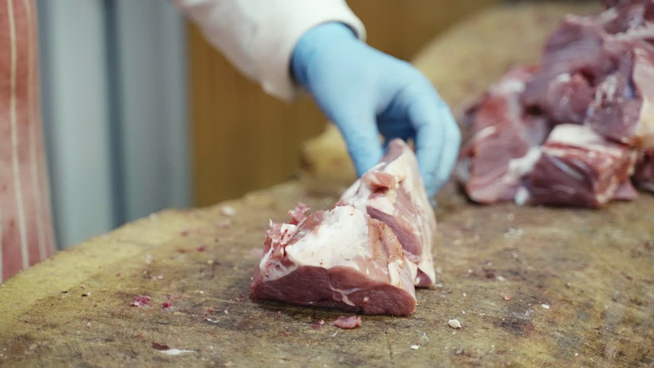 Vídeo Premium Un carnicero corta carne cruda con una cuchilla