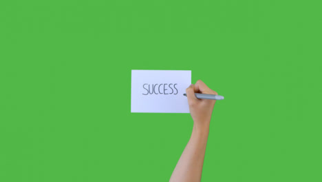 Woman-Writing-Success-on-Paper-with-Green-Screen