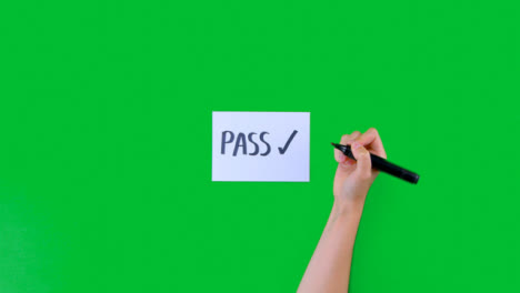 Woman-Writing-Pass-with-a-Tick-on-Paper-with-Green-Screen