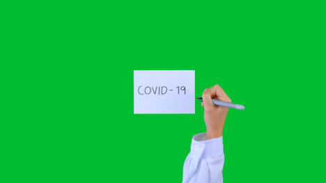 Arzt-Schreibt-Covid-19-Auf-Papier-Mit-Grünem-Bildschirm