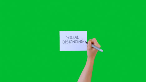 Frau-Schreibt-Soziale-Distanzierung-Auf-Papier-Mit-Grünem-Bildschirm