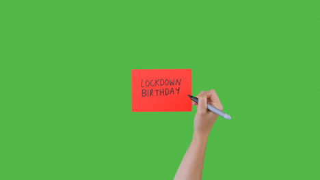 Woman-Writing-Lockdown-Birthday-on-Paper-with-Green-Screen