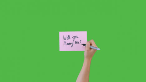 Woman-Writing-Will-You-Marry-Me-on-Paper-with-Green-Screen