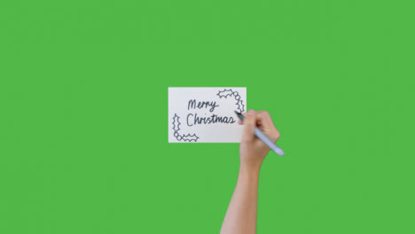 Frau-Schreibt-Frohe-Weihnachten-Auf-Papier-Mit-Grünem-Bildschirm