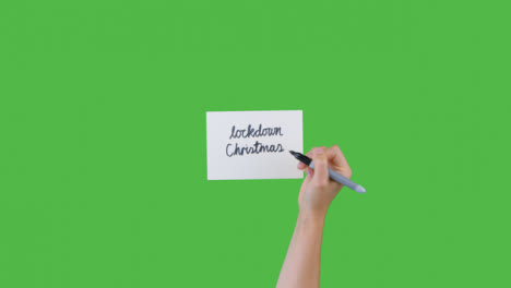 Frau-Schreibt-Lockdown-Weihnachten-Auf-Papier-Mit-Grünem-Bildschirm