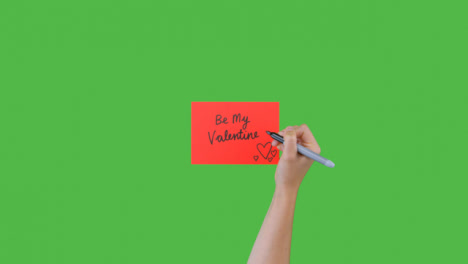 Woman-Writing-Be-My-Valentine-on-Paper-with-Green-Screen