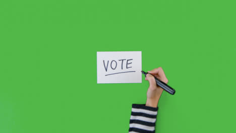 Frau-Schreibt-Abstimmung-Auf-Papier-Mit-Grünem-Bildschirm