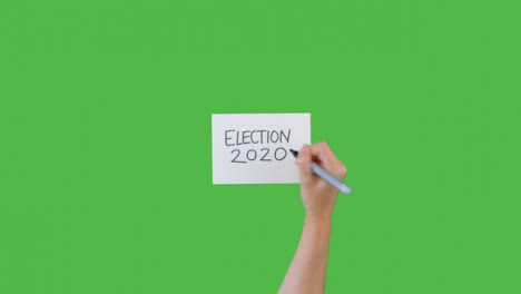 Mujer-Escribiendo-Elecciones-2020-En-Papel-Con-Pantalla-Verde