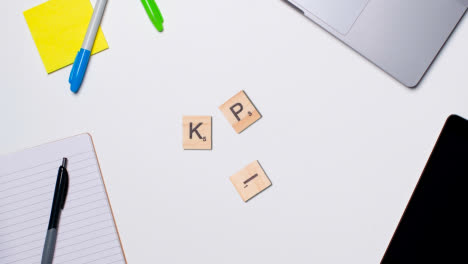 Stop-Motion-Business-Concept-Above-Desk-Wooden-Letter-Tiles-Forming-Acronym-KPI