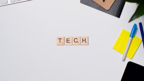 Stop-Motion-Business-Concept-Above-Desk-Wooden-Letter-Tiles-Forming-Word-Tech