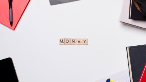 Stop-Motion-Business-Concept-Above-Desk-Wooden-Letter-Tiles-Forming-Word-Money