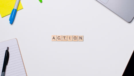 Stop-Motion-Geschäftskonzept-über-Dem-Schreibtisch-Aus-Holzbuchstaben,-Die-Wortaktion-1-Bilden