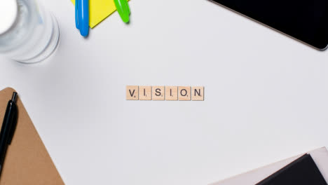 Stop-Motion-Business-Concept-Above-Desk-Wooden-Letter-Tiles-Forming-Word-Vision