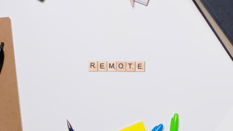 Stop-Motion-Business-Concept-Above-Desk-Wooden-Letter-Tiles-Forming-Word-Remote