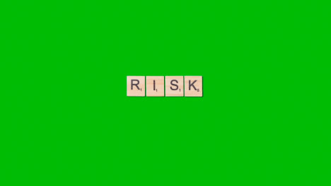 Stop-Motion-Business-Concept-Overhead-Wooden-Letter-Tiles-Forming-Word-Risk-On-Green-Screen