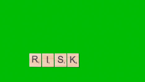 Stop-Motion-Business-Concept-Overhead-Wooden-Letter-Tiles-Forming-Word-Risk-On-Green-Screen-1