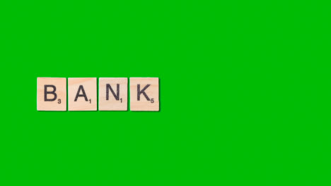 Stop-Motion-Business-Concept-Overhead-Wooden-Letter-Tiles-Forming-Word-Bank-On-Green-Screen-1