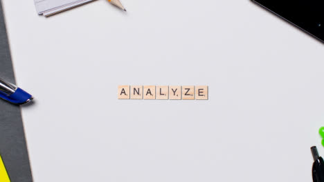 Stop-Motion-Business-Concept-Above-Desk-Wooden-Letter-Tiles-Forming-Word-Analyse