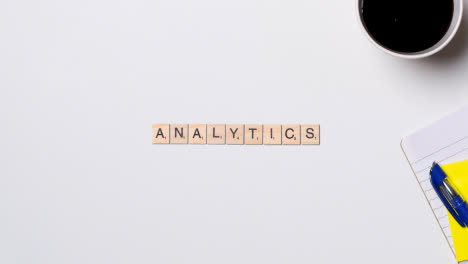 Stop-Motion-Business-Concept-Above-Desk-Wooden-Letter-Tiles-Forming-Word-Analytics