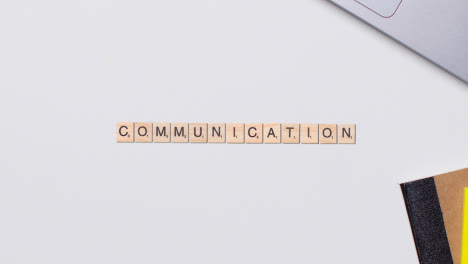 Stop-Motion-Business-Concept-Above-Desk-Wooden-Letter-Tiles-Forming-Word-Communication