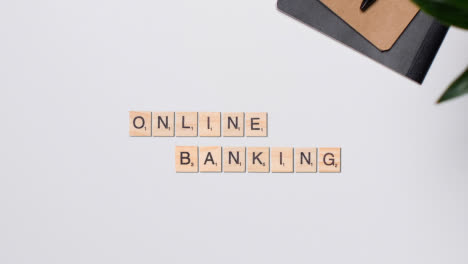 Stop-Motion-Geschäftskonzept-über-Dem-Schreibtisch-Holzbuchstabenfliesen,-Die-Wörter-Online-Banking-Bilden
