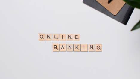 Stop-Motion-Business-Concept-Above-Desk-Wooden-Letter-Tiles-Forming-Words-Online-Banking