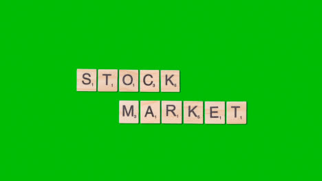 Stop-Motion-Business-Concept-Overhead-Wooden-Letter-Tiles-Forming-Words-Stock-Market-On-Green-Screen-1