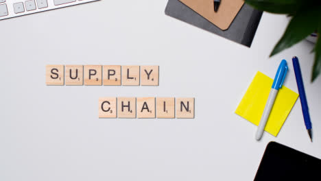 Stop-Motion-Business-Concept-Above-Desk-Wooden-Letter-Tiles-Forming-Words-Supply-Chain-1