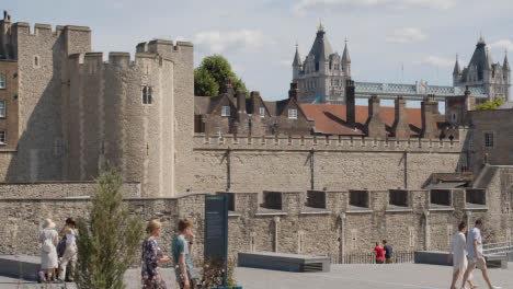Exterior-Of-The-Tower-Of-London-England-UK-With-Tourists-And-Tower-Bridge-Behind