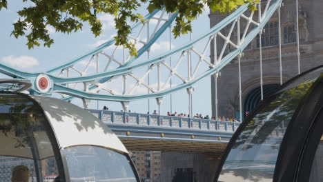 Menge-Von-Sommertouristen,-Die-An-Der-Tower-Bridge-London-England-UK-Mit-Restaurant-Pods-Im-Vordergrund-2-Spazieren