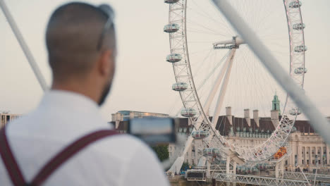 Hombre-Grabando-Video-En-Un-Teléfono-Móvil-Usando-Cardán-Del-London-Eye-Inglaterra