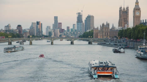 Touristisches-Sightseeing-Boot,-Das-Passagiere-Für-Eine-Fahrt-Auf-Der-Themse-In-Der-Abenddämmerung-An-Den-Parlamentsgebäuden-Vorbeiführt