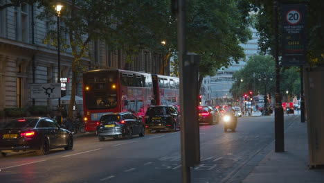 Tráfico-Nocturno-Con-Autobuses-Y-Automóviles-En-La-Concurrida-Calle-De-Londres,-Inglaterra,-Reino-Unido-Al-Atardecer