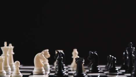 Studio-Shot-Chess-Board-And-Pieces-Set-Up-For-Game-With-Black-Knight-Taking-White-Knight