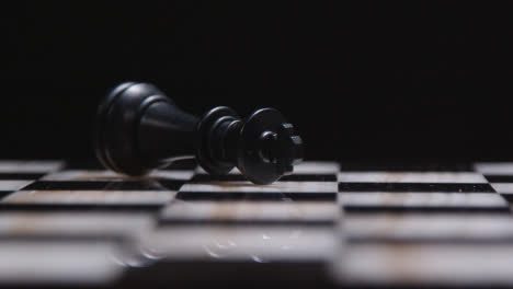 Studio-Shot-Chess-Board-With-Black-King-Resigning-Knocked-Over