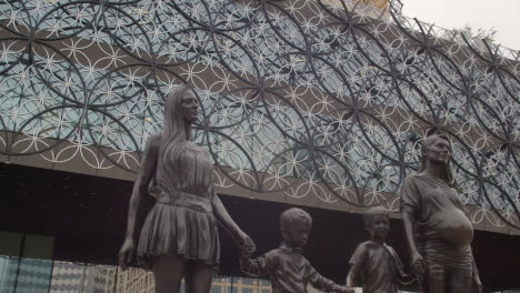 Exterior-Of-Modern-Building-And-Statue-Of-Family-In-Centenary-Square-In-Birmingham-UK