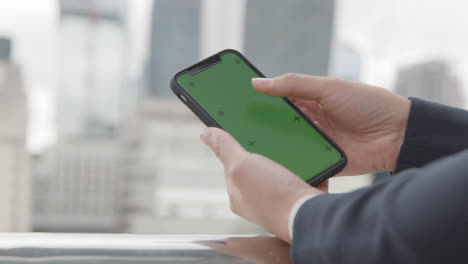 Close-Up-Of-Businessman-Using-Green-Screen-Mobile-Phone-Outdoors