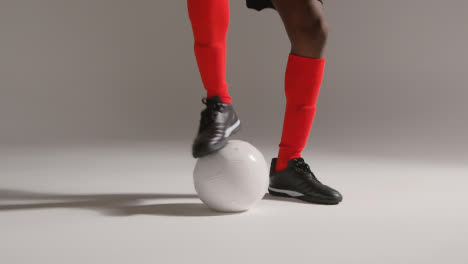 Primer-Plano-Del-Estudio-De-Un-Futbolista-Masculino-Que-Lleva-Un-Kit-De-Club-Regateando-Con-El-Balón-1
