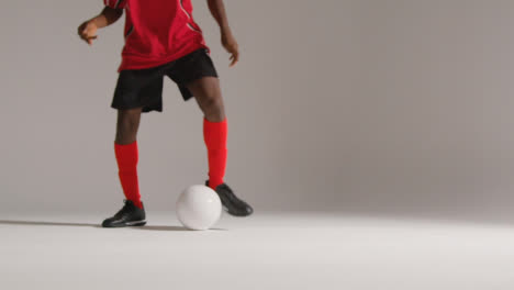Studio-Close-Up-Of-Male-Footballer-Wearing-Club-Kit-Dribbling-With-Ball-2