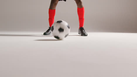 Close-Up-Of-Male-Footballer-In-Studio-Controlling-And-Passing-Ball-4