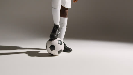 Close-Up-Of-Male-Footballer-In-Studio-Playing-Keepy-Uppy-Kicking-Ball-5