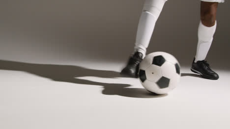 Studio-Close-Up-Of-Male-Footballer-Wearing-Club-Kit-Dribbling-With-Ball-4
