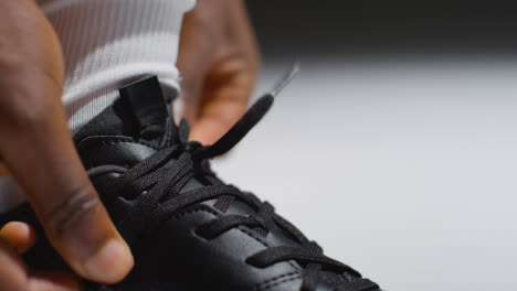 Studio-Close-Up-Of-Male-Footballer-Or-Sportsperson-Tying-Laces-On-Boots-Or-Training-Shoes-4