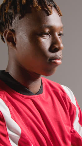 Vertical-Video-Studio-Portrait-Of-Young-Male-Footballer-Wearing-Club-Kit-