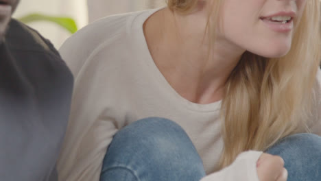 Close-Up-Of-Disappointed-Multi-Cultural-Friends-Watching-Sports-Game-On-TV-Sitting-On-Sofa-At-Home-Together