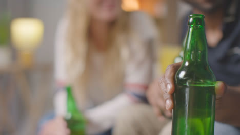 Multikulturelle-Freunde-Sitzen-Zu-Hause-Auf-Dem-Sofa,-Reden,-Trinken-Bier-Und-Jubeln-1