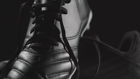 Studio-Still-Life-Shot-Of-Football-Soccer-Boots-Against-Black-Background