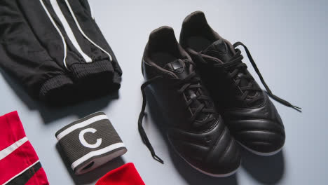 Studio-Still-Life-Shot-Of-Football-Soccer-Boots-Ball-Shirt-And-Shorts-And-Captains-Armband-3