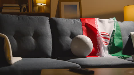 Sofa-In-Lounge-With-Iranian-Flag-And-Ball-As-Fans-Prepare-To-Watch-Football-Soccer-Match-On-TV-