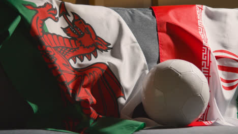 Sofa-In-Lounge-With-Welsh-And-Iranian-Flags-And-Ball-As-Fans-Prepare-To-Watch-Football-Soccer-Match-On-TV-1